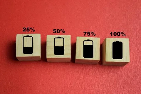 Battery charge level indicator with numbered text stacked wooden cubes Stock Photos