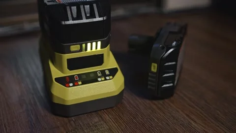 Battery charging on desktop power tool charger with indicator lights Stock Footage 333959993