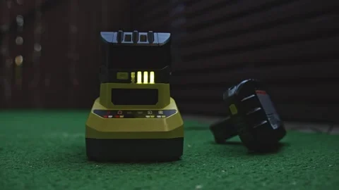 Battery charging on power tool charger with indicator lights showing level Stock Footage 333959559
