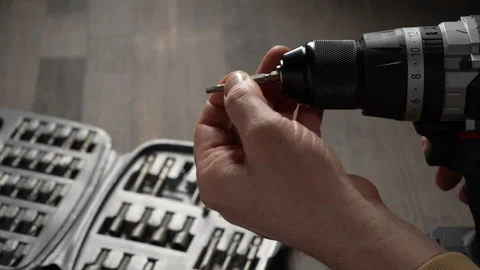 Battery cordless screwdriver and set screwdriver bits on a wooden background Stock Footage 333240391