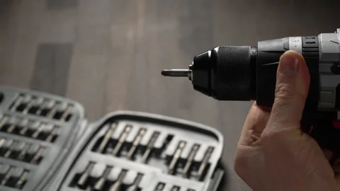 Battery cordless screwdriver and set screwdriver bits on a wooden background Stock Footage 334046198