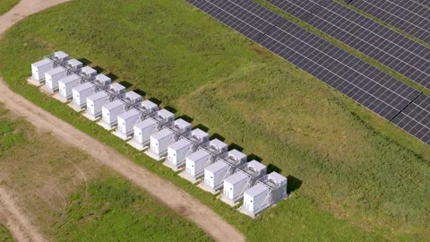 Battery storage system containers in a green photovoltaic solar field Stock Footage 346965783