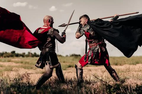 Battle between two ancient warriors in battle dress and cloaks. Stock Photos