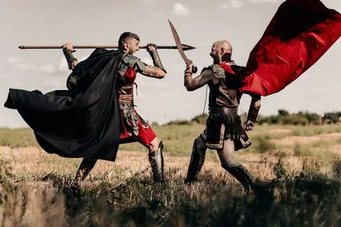 Battle between two ancient warriors in battle dress and cloaks. Stock Photos