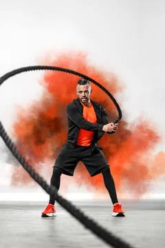 Battle rope functional training. Man on cross exercises. Fit athletic man doing Stock Photos
