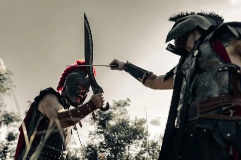 Battle with swords between two ancient warriors on meadow. Stock Photos