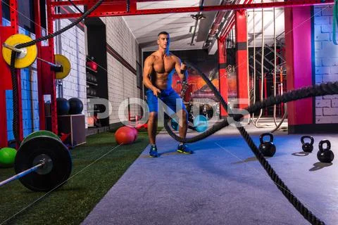 Battling ropes man at gym workout exercise Stock Photos