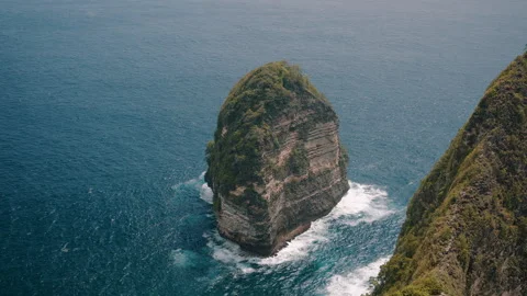 Batu Raharja rock surrounded by ocean waves at Kelingking Beach Stock Footage 306809502