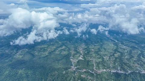 Batur Caldera emerald patchwork unfolds beneath drifting clouds. Endless 스톡 사진