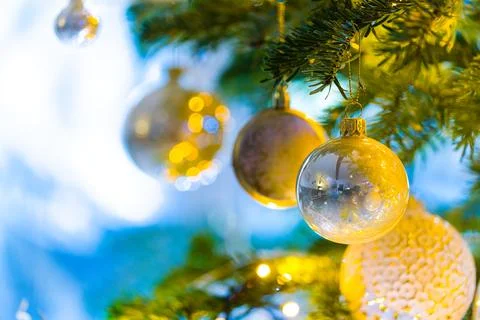 Baubles Adorn a Christmas Tree with Twinkling Lights in the Background. Stock Photos
