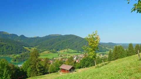 Bavarian lake surrounded by forested slopes and blue skies, a hidden summer r Stock Footage 309096232