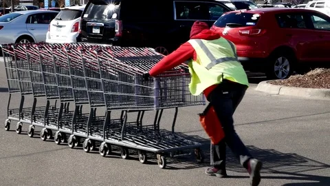 BAXTER, MN - 29 MAR 2019: Costco shopping cart attendant pushes shopping carts. Stock Footage 106908738