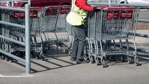 BAXTER, MN - 29 MAR 2019: Costco shopping cart attendant moves shopping carts. Video stock 106908786