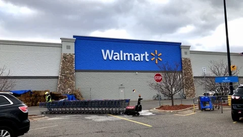 BAXTER, MN - 4 NOV 2019: Walmart Shopping Cart Attendant in bright green vest Stock Footage 128471906