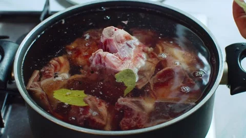 Bay leaf is added to a pot with bones and water. 動画素材 312720041