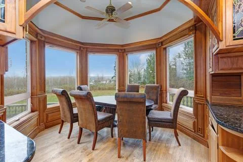 Bay window breakfast nook features large windows framing an oval antique dini Stock Photos