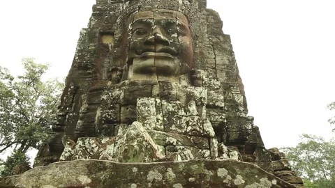 Bayon temple smooth glide with low shot of stone face Stock Footage 76381231