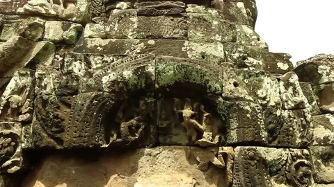 Bayon temple smooth tilt from base of sculpture to stone face, low wide angle Stock Footage 76381869