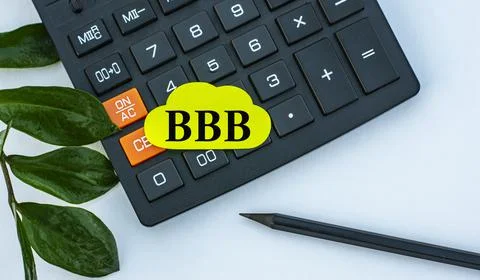 BBB - word on a yellow note sheet on a white background with a calculator, pe Stock Photos