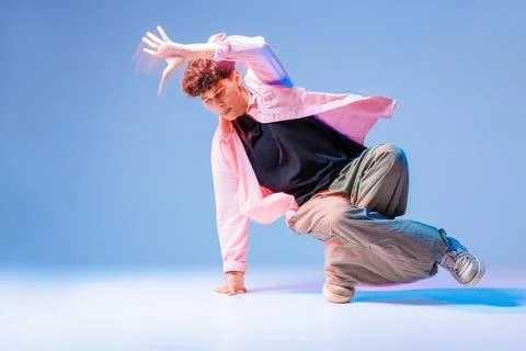 Bboy breakdance freeze with dynamic footwork in neon studio low angle copy .. Stock Photos