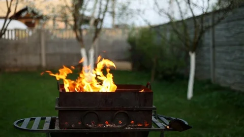 BBQ. Barbecue in the backyard in the late evening in the summer . Flames of fire Vídeos de archivo 112949479
