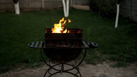 BBQ. Barbecue in the backyard in the late evening in the summer . Flames of fire Stock Footage 112949544