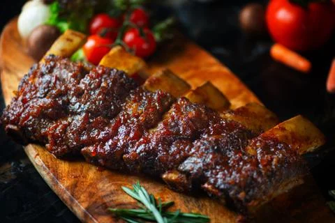BBQ beef ribs steak served with a hot chili pepper and fresh tomatoes on an o Stock Photos
