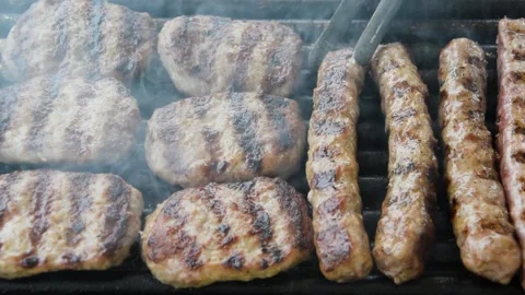 BBQ Checking out Meatballs and Kebabs on a Tube Grill Stock Footage 248548828