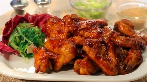 BBQ chicken wings served hot on plate. Sprinkling seasame seeds chives Stock Footage 106827744