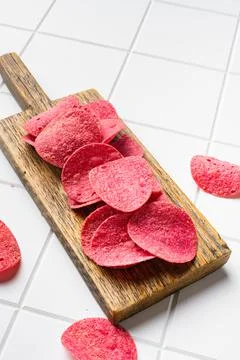 BBQ Flavored Red Potato Chips on white ceramic squared tile table background Stock Photos
