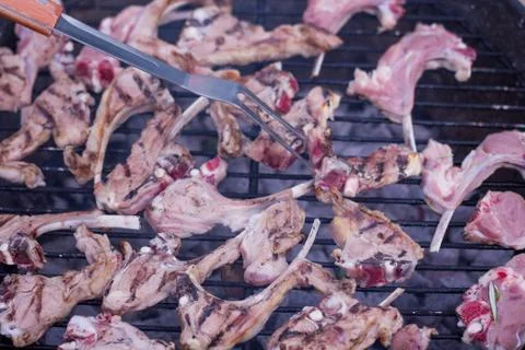 BBQ fork putting lamb ribs into the grill. Foto stock