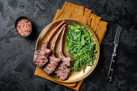 BBQ grilled lamb cutlet or mutton chop steak with arugula salad on a plate Stock Photos