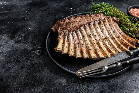 BBQ Grilled rack of Lamb mutton Ribs Chops on plate with thyme. Black background Stock Photos
