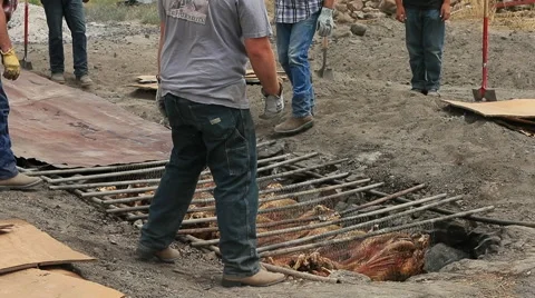 BBQ in ground rock lines pit lamb dinner HD Video stock 65118219