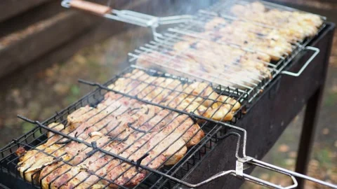 BBQ. Meat lying on the grill is fried on coals. Video stock 142878622