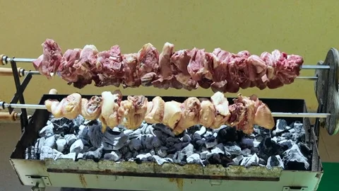 BBQ Meat Over Rotating Coals – Spit Roast Style Grilling 4K Close-Up Stock Footage 333981907