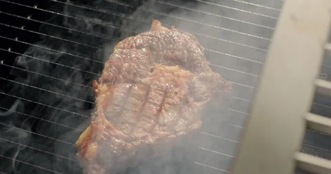 BBQ meat steak grilling on barbecue grill. Grilling BBQ meat. Smoke rising over Stock Footage 277491502