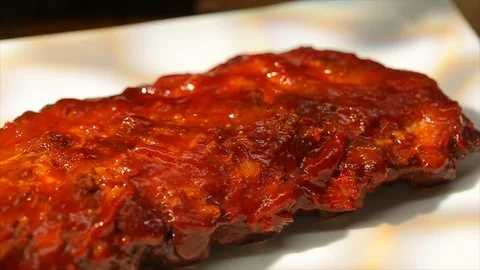BBQ ribs steaming hot on plate. Cutting with fork and knife cu Stock Footage 106827586