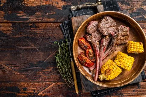 BBQ Roasted chops steaks of lamb, mutton in a wooden plate. Dark wooden Stock Photos