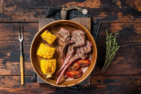 BBQ Roasted chops steaks of lamb, mutton in a wooden plate. Dark wooden Stock Photos