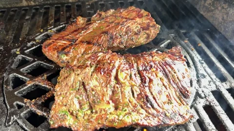 BBQ Steak Cooking on Grill With Flames and Smoke Rising Close-Up Stock Footage 311389331