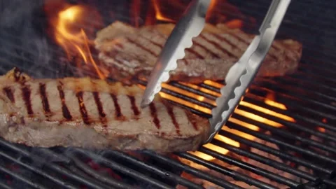 BBQ steak on grill. Grilling on open fire meat. Slow motion Stock Footage 156929365