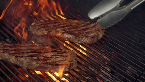 BBQ steak on grill. Grilling on open fire meat. Slow motion Stock Footage 156930112