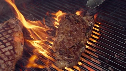 BBQ steak on grill. Grilling on open fire meat. Slow motion Stock Footage 156930442