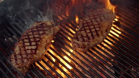BBQ steak on grill. Grilling on open fire meat. Slow motion Stock Footage 156930490