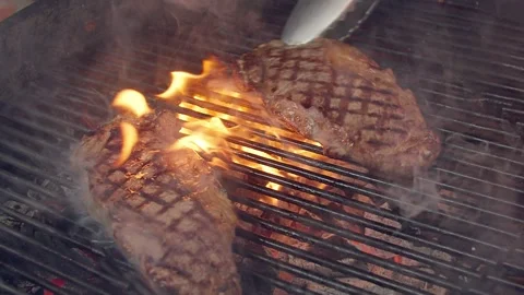 BBQ steak on grill. Grilling on open fire meat. Slow motion Stock Footage 156930620