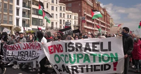 BDS Protest marching with Free-Palestine signs in the streets of Brighton, U Stock Footage