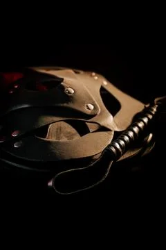 BDSM mask resting on a dark surface with subtle hints of smoke Stock Photos
