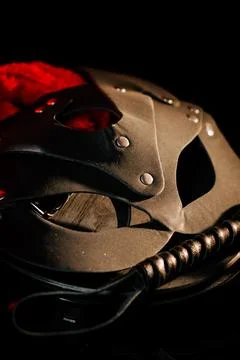 BDSM mask resting on a dark surface with subtle hints of smoke Stock Photos