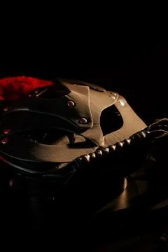 BDSM mask resting on a dark surface with subtle hints of smoke Stock Photos